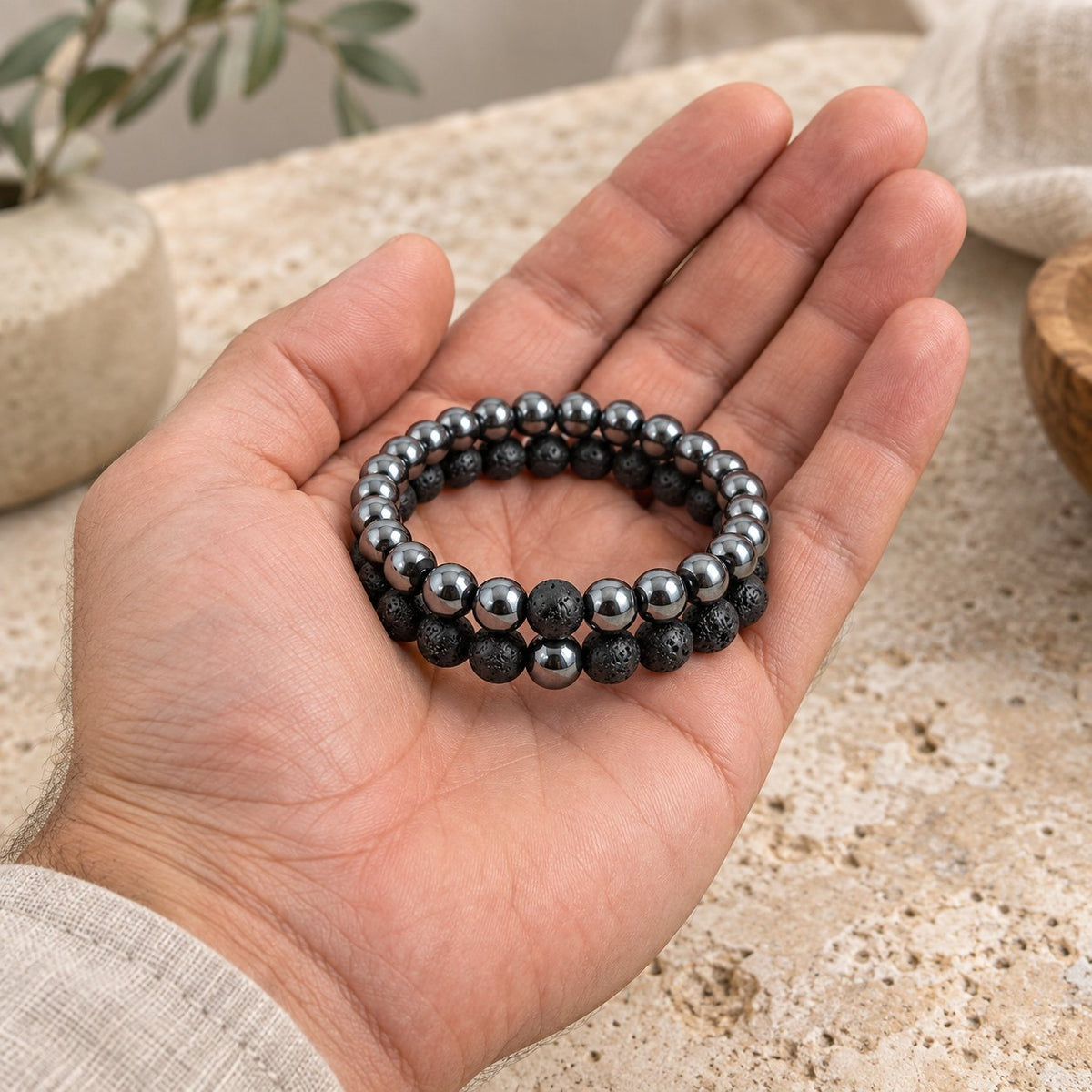Hematite and Lava Stone Balance Bracelets, held in the hand to show its real size