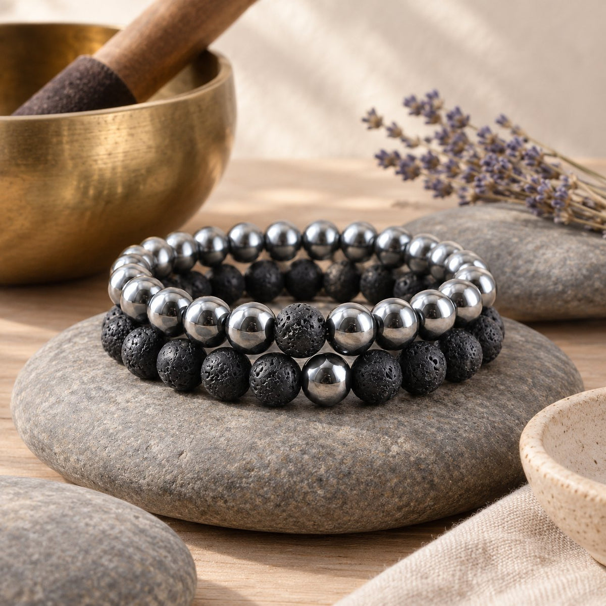 Hematite and Lava Stone Balance Bracelets, styled with a singing bowl and lavender