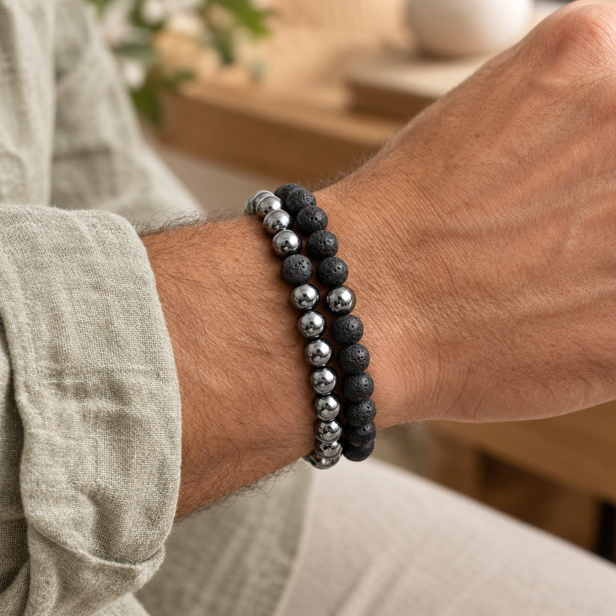 Hematite and Lava Stone Balance Bracelets, worn on the wrist by a man