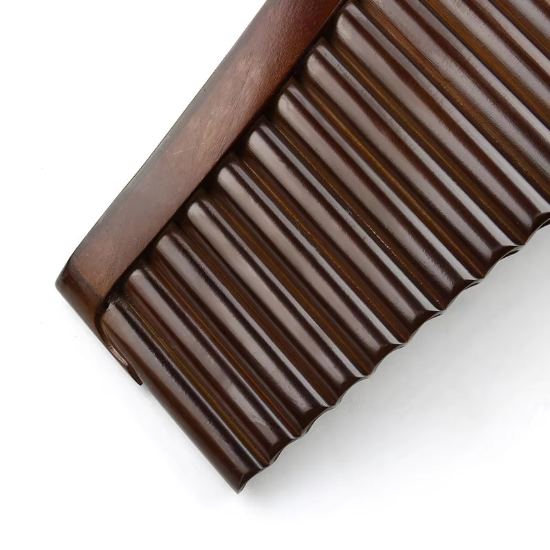 Dark chocolate bar with ridged segments next to High-Quality Bamboo Pan Flute