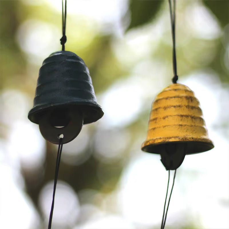 Two bell-shaped black and yellow Japanese Cast Iron Wind Chimes for garden decor