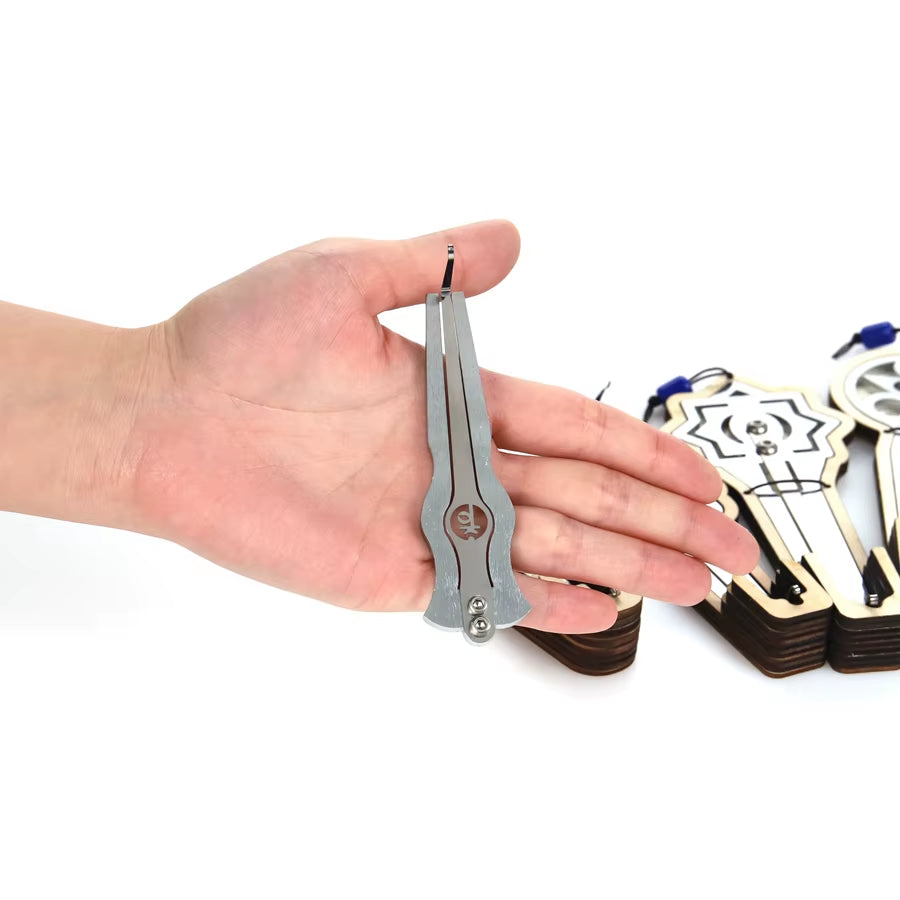 Metal pliers held in an open palm next to Jaw Mouth Harp Instrument - E Major