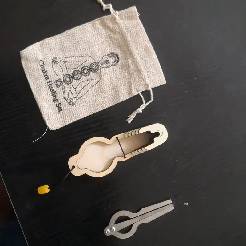 Cream-colored plastic chastity device with cloth storage bag next to Jew Harp Musical Instrument