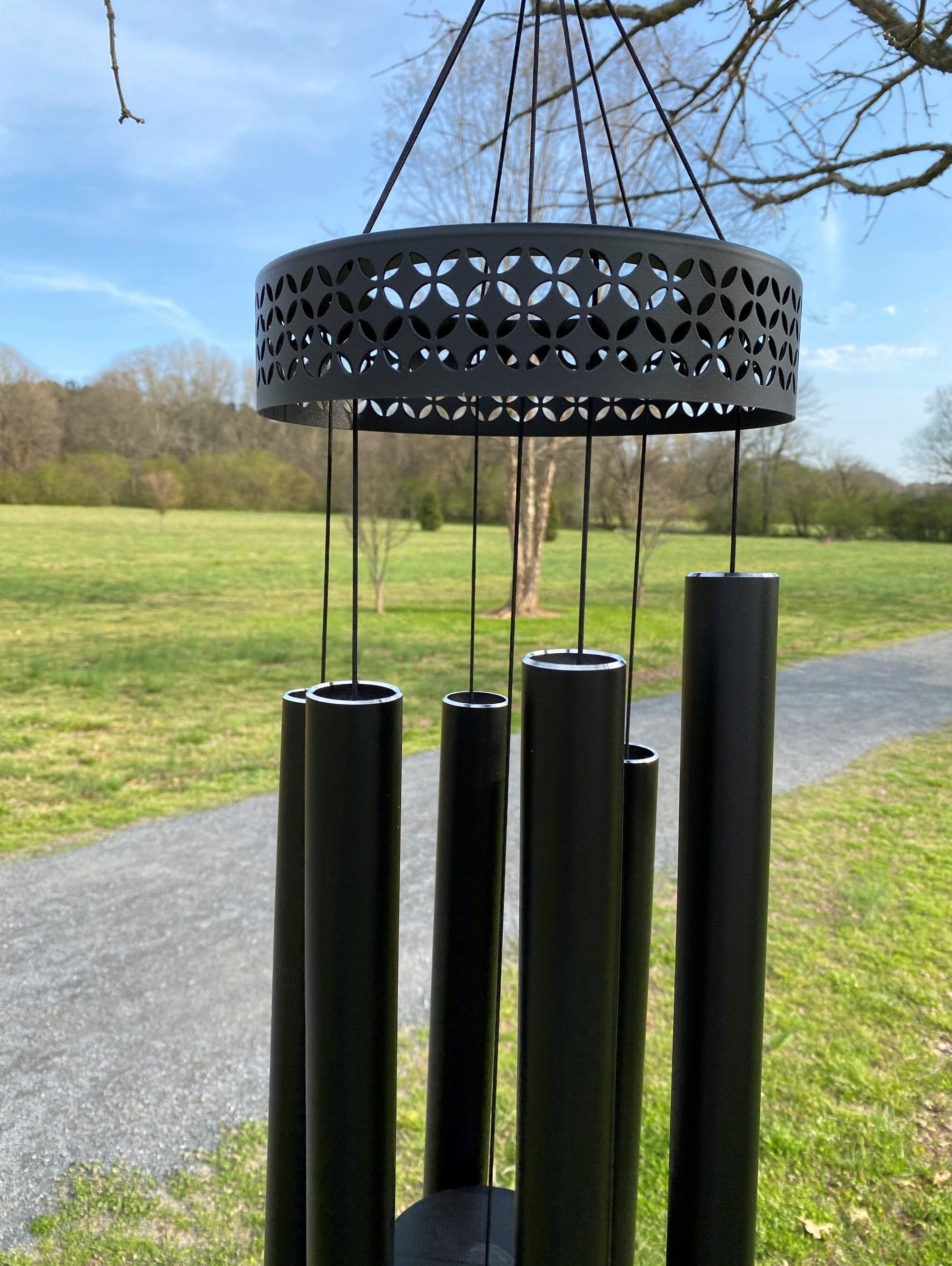 Black metal wind chimes with circular top and tubular chimes for memorial use