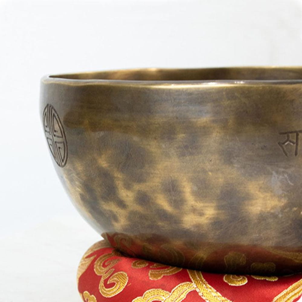 Large Tibetan Singing Bowl on a red and gold cushion for healing and meditation