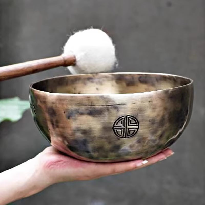 Large Tibetan Singing Bowl with Buddhist symbol, struck by a mallet for meditation therapy