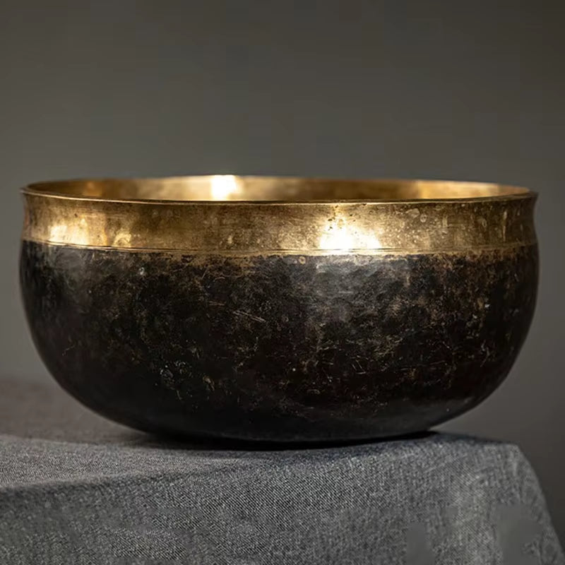 Large Tibetan Singing Bowl with dark patina and golden rim for meditation and yoga