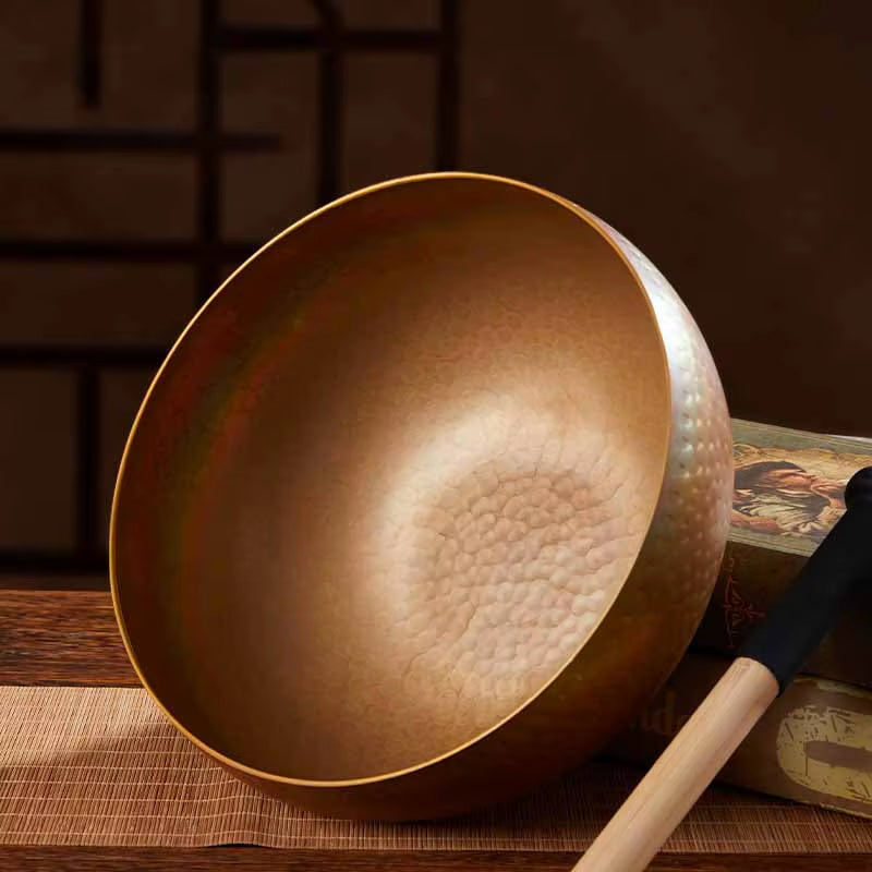 Metallic Tibetan singing bowl with wooden striker for sound therapy and healing