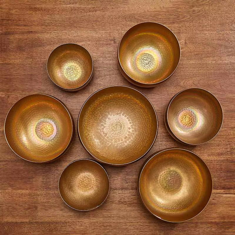 Collection of golden Tibetan singing bowls arranged in a circle for healing therapy