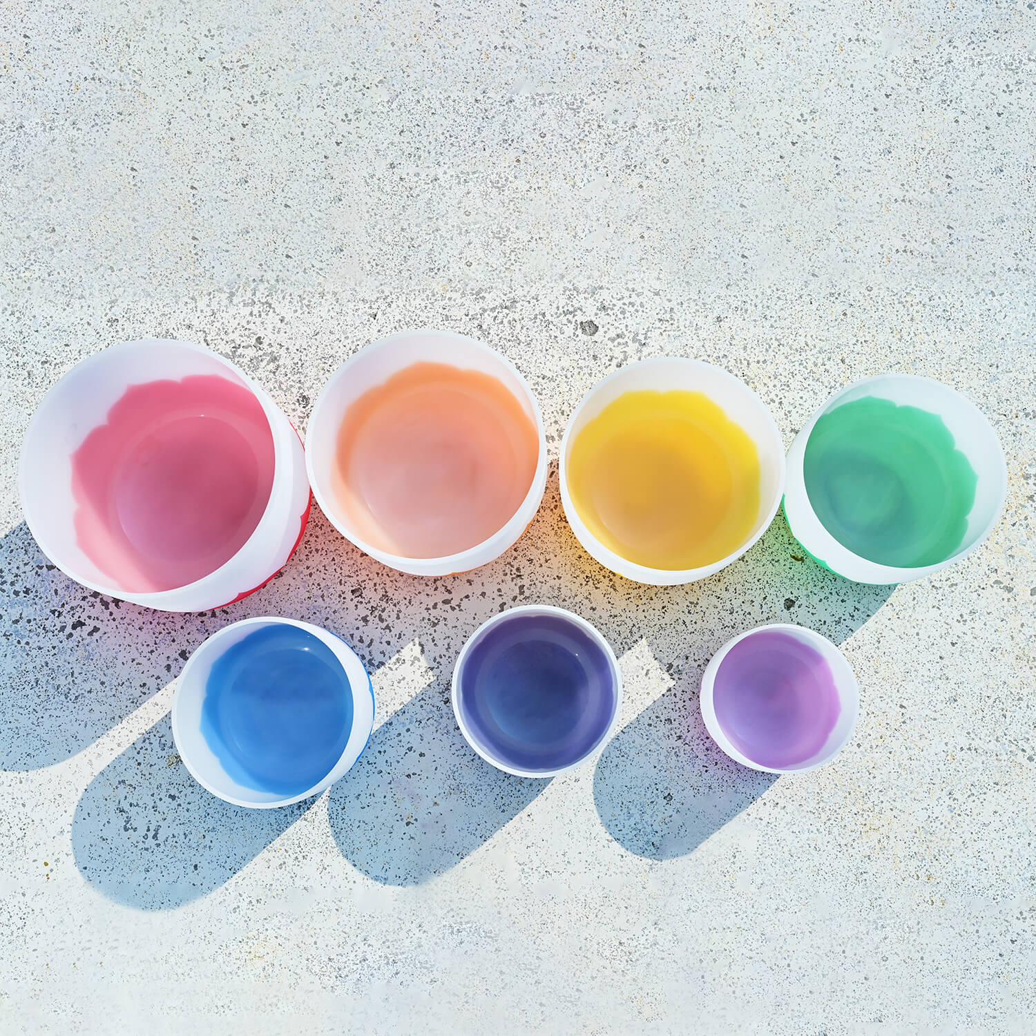 Seven colorful plastic cups in rainbow pattern for Chakra healing with Lotus Frosted Quartz