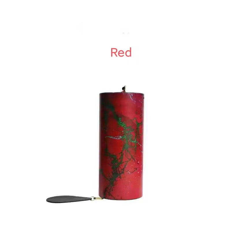 Red cylindrical candle with green marbled pattern in Metal Koshi Wind Chimes display