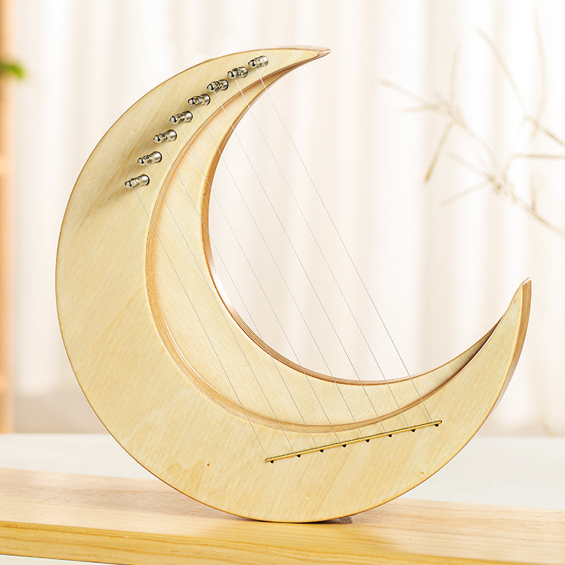 Decorative wooden crescent moon with string details on Moon Lyre Harp Instrument