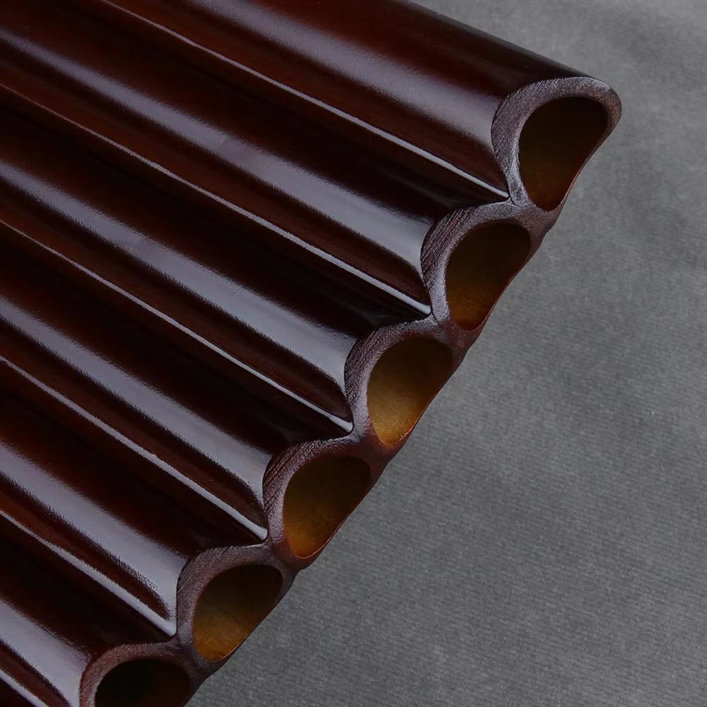 Dark chocolate tubes in a row showcasing the Natural Bamboo Pan Flute 25 Pipes G Key Instrument