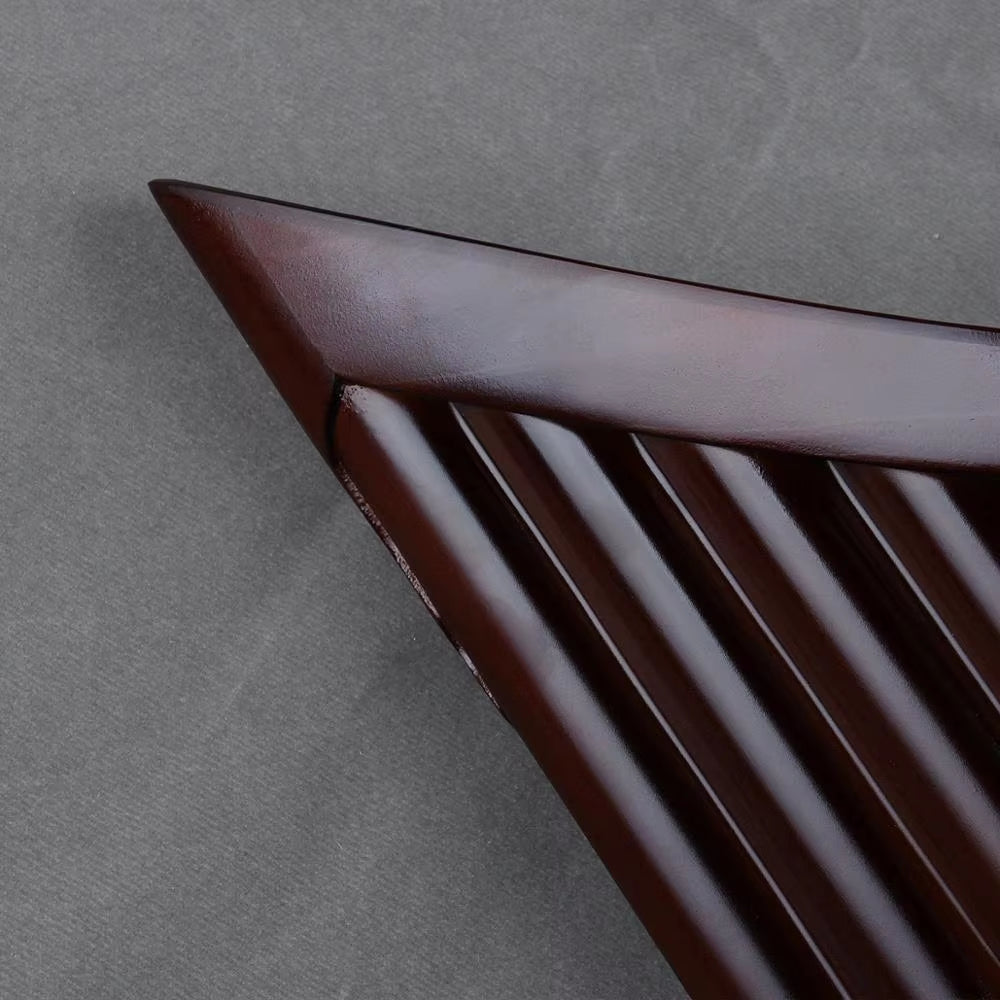 Triangular dark chocolate with ridges alongside Natural Bamboo Pan Flute instrument