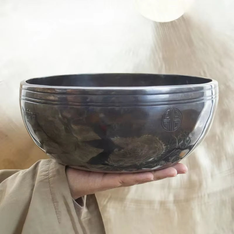 Dark metallic singing bowl with engraved symbols, part of Nepal Handmade Buddhist Sound Bowls