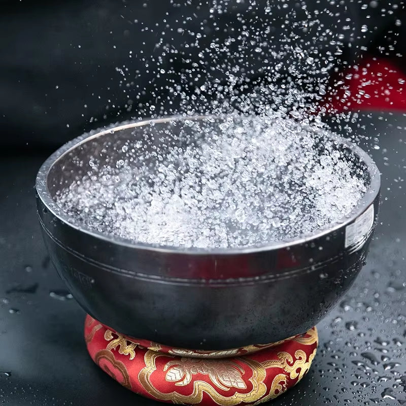 Black bowl with splashing white powder on red and gold cushion, Nepal Handmade Buddhist Sound Bowls