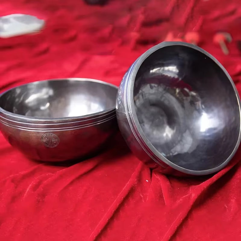 Two metallic singing bowls on red fabric for Nepal Handmade Buddhist Sound Bowls