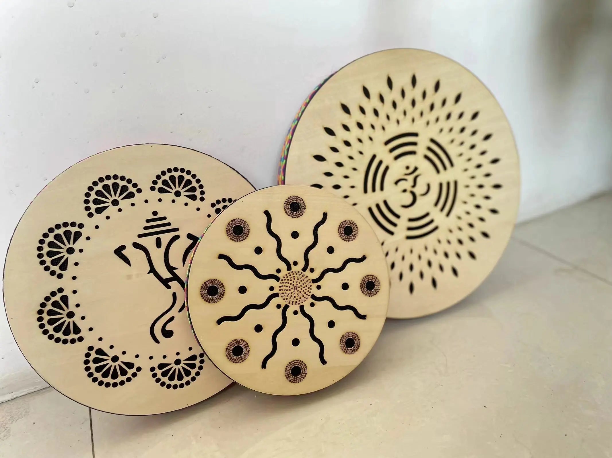 Three wooden discs with laser-cut mandala patterns for Ocean Drum Instrument