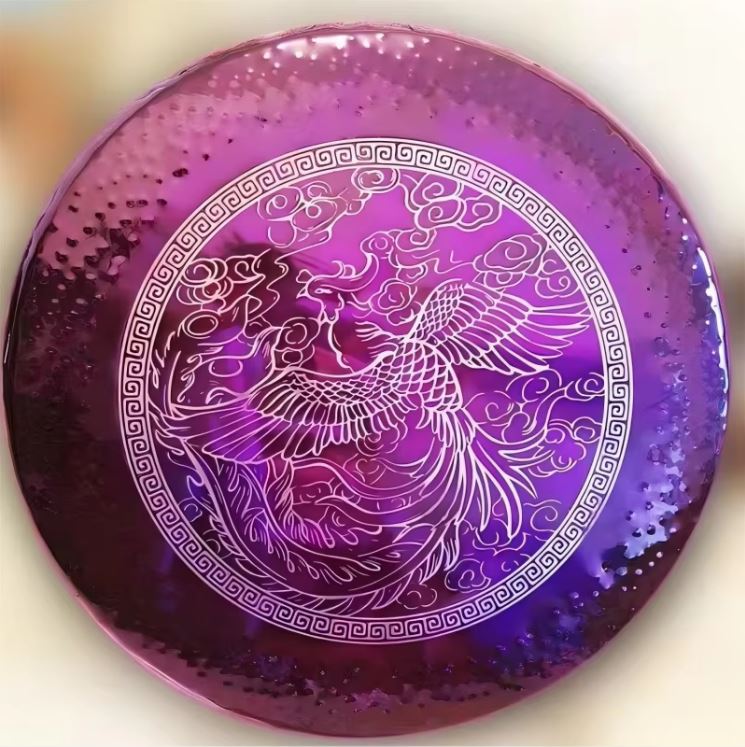 Metallic purple disc engraved with a phoenix design and Greek key border for sound healing