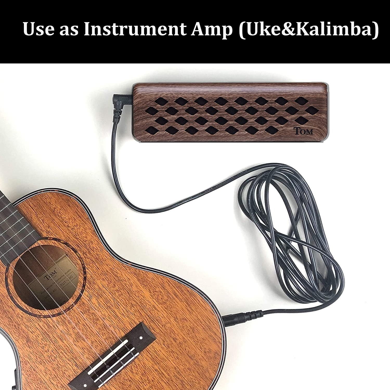 Wooden instrument amplifier with diamond holes connected to a ukulele via black cable