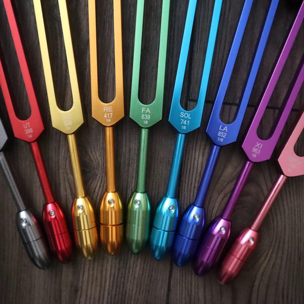 Rainbow-colored tuning forks in a spectrum from red to purple for crystal massage set