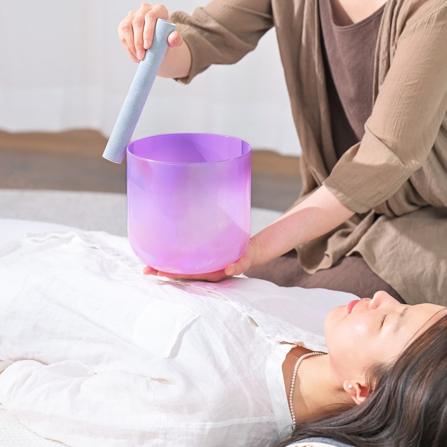 Purple Crystal Singing Bowl being played with a mallet for Sound Healing