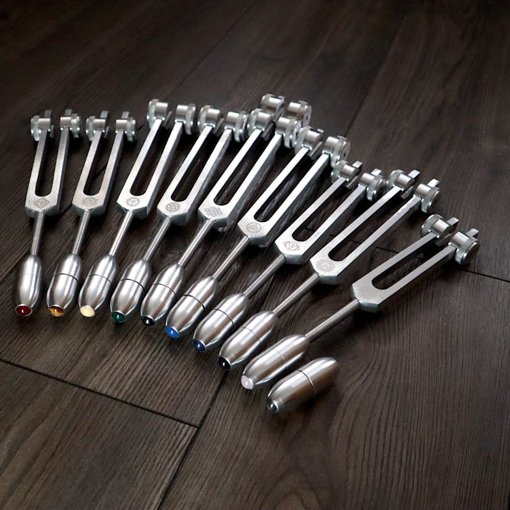 Collection of Silver Chakra Tuning Forks arranged in a fan pattern for healing therapy