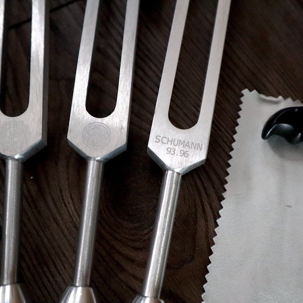 Metal tuning forks lined up in the Silver Chakra Tuning Forks Set with Crystal Massage Kit