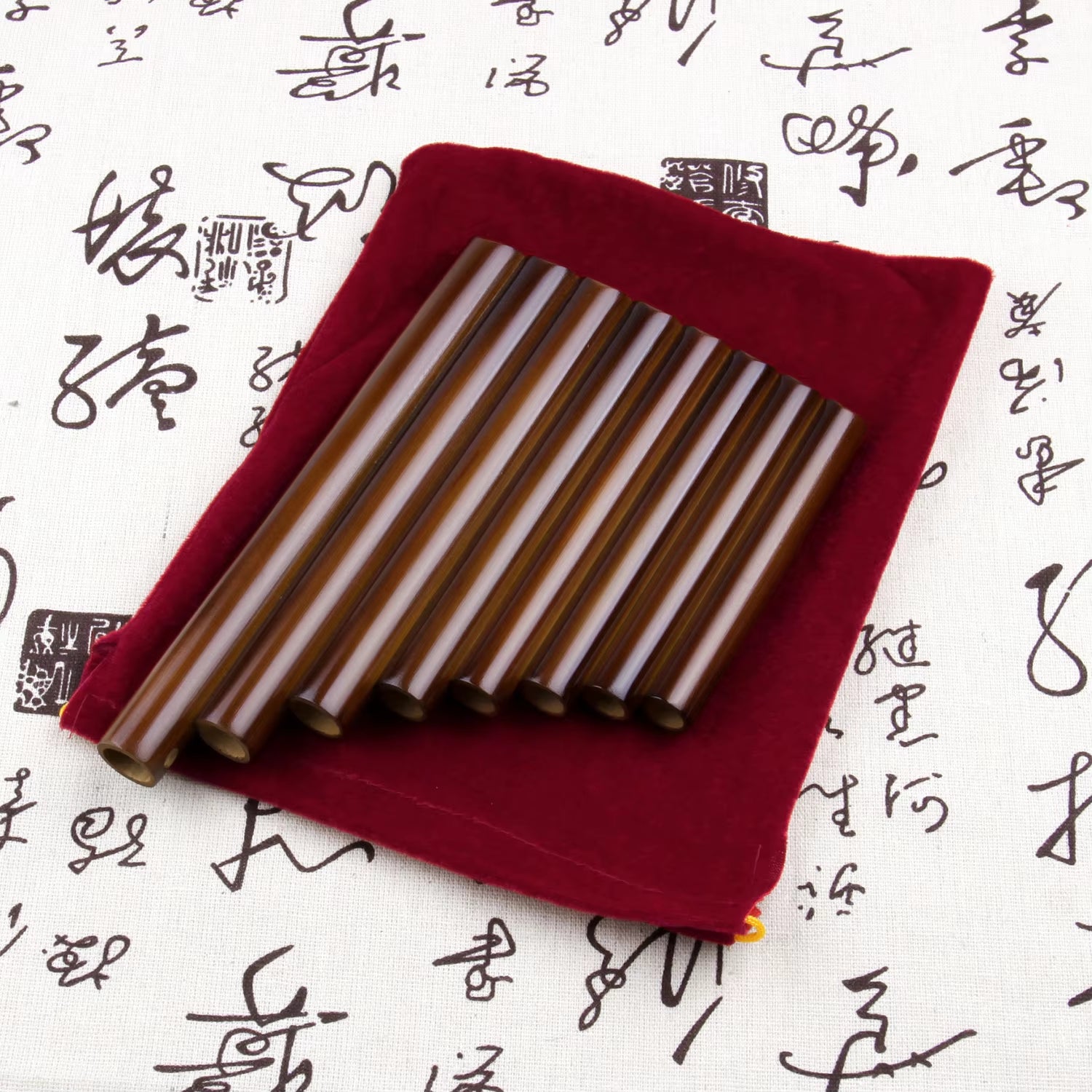 Metal acupuncture needles on red fabric for Small Brown Bamboo Pan Flute display