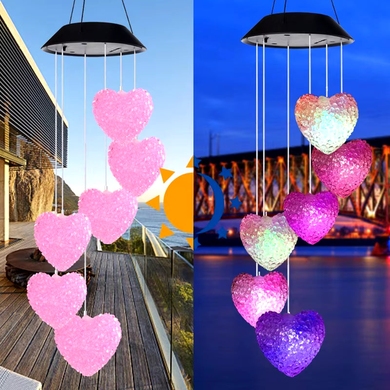 Heart-shaped wind chimes with color-changing LEDs hanging from a black umbrella top