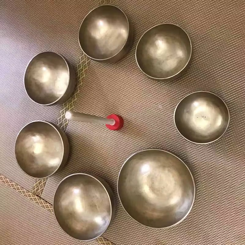 Seven metallic Tibetan singing bowls arranged in a circle for meditation sound healing