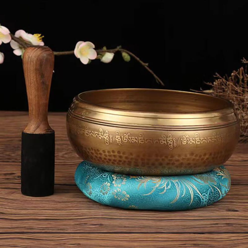 Tibetan singing bowl on turquoise cushion with decorative Sanskrit inscriptions for meditation