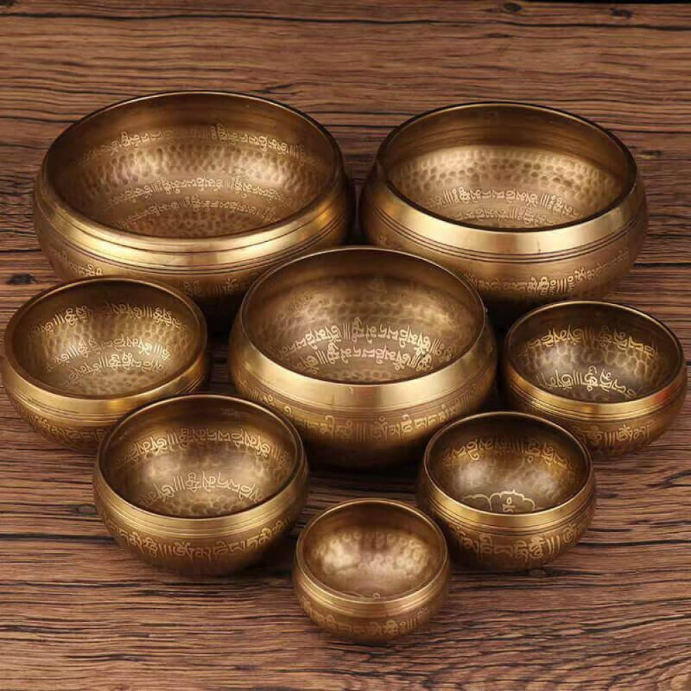 Collection of brass Tibetan Singing Bowls arranged in a circular pattern for meditation