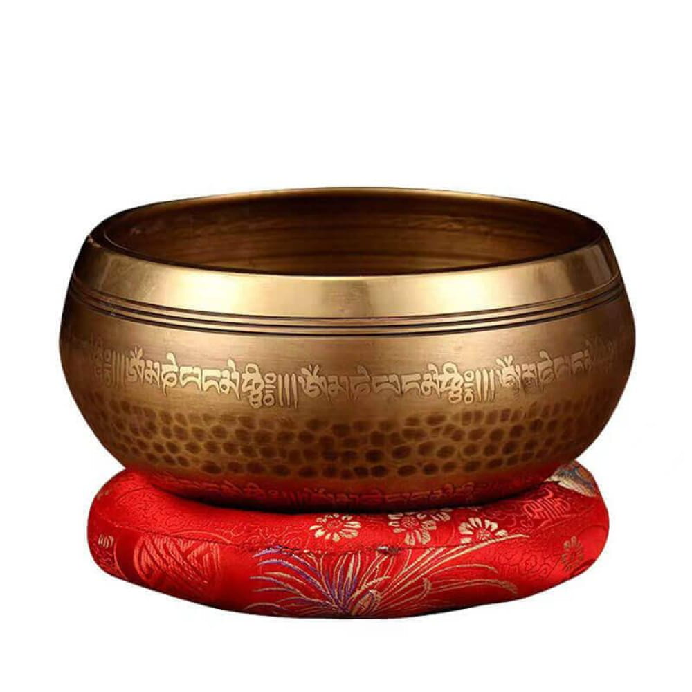 Tibetan Singing Bowl on red cushion with floral embroidery for meditation and sound healing