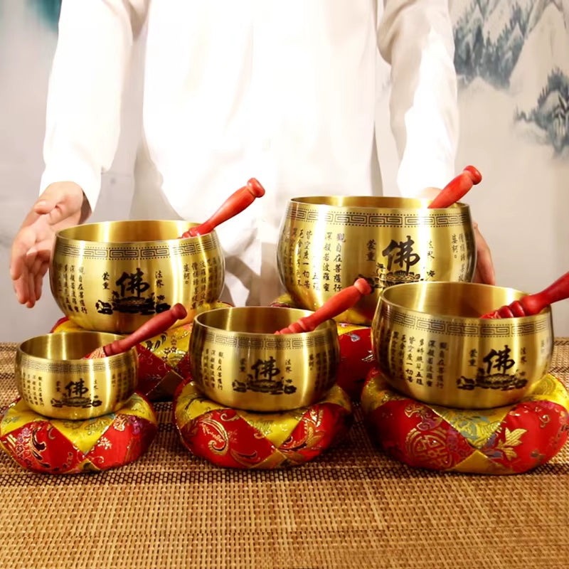 Tibetan singing bowls with red mallets on decorative red cushions for meditation healing