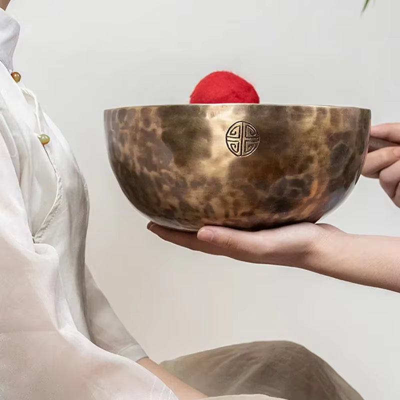 Bronze Tibetan singing bowl with ornate Asian symbol for meditation and healing