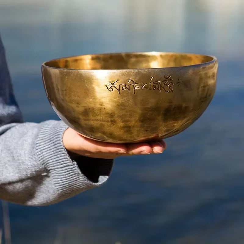 Golden Tibetan singing bowl with etched script, perfect for meditation and healing