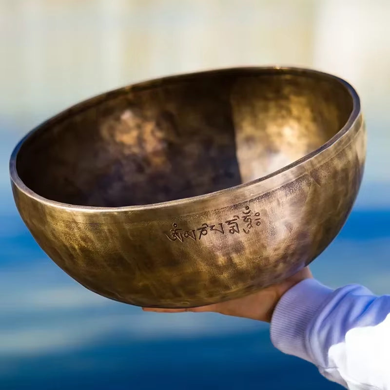 Hammered brass Tibetan singing bowl with Sanskrit inscriptions for meditation and healing