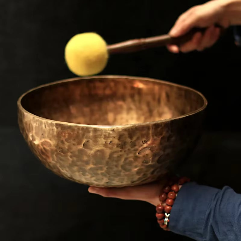 Hammered copper Tibetan singing bowl with mallet for meditation and sound healing