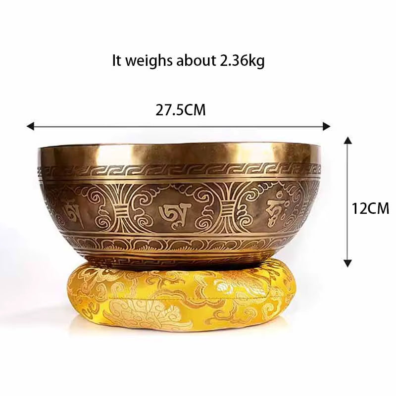 Bronze Tibetan singing bowl with geometric patterns on a yellow cushion for healing