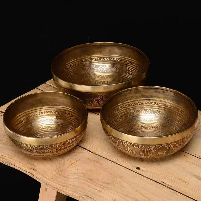 Three ornate brass Tibetan singing bowls with decorative etchings for healing