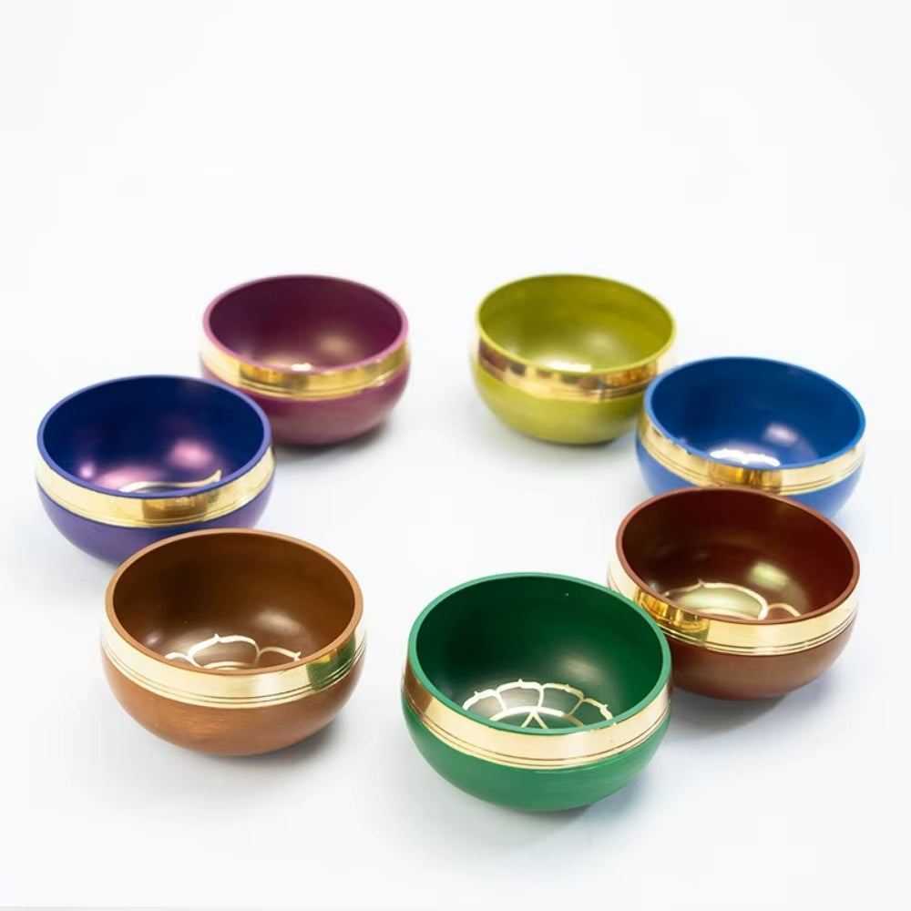 Colorful Tibetan Singing Bowls with gold trim arranged in a circular pattern for meditation