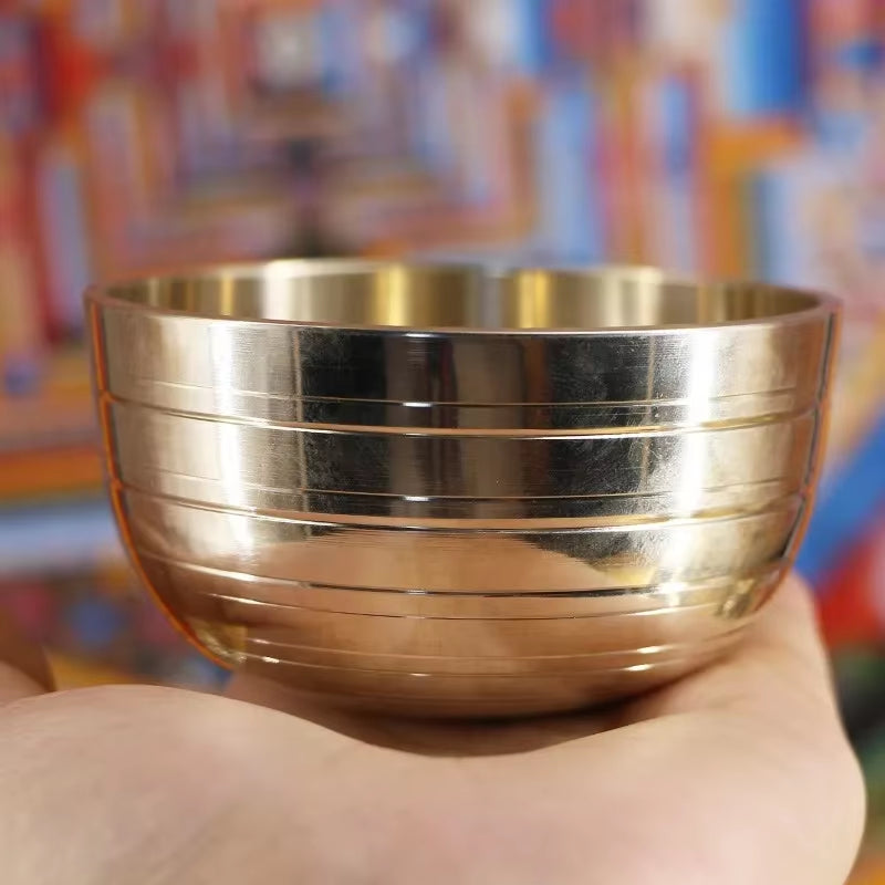 Metallic gold Tibetan Singing Bowl with grooved lines for sound healing therapy