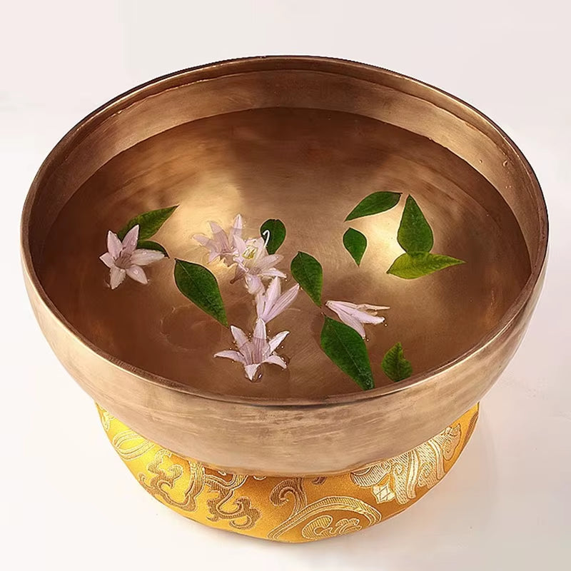 Bronze Tibetan Singing Bowl with flowers and leaves floating in water for meditation healing