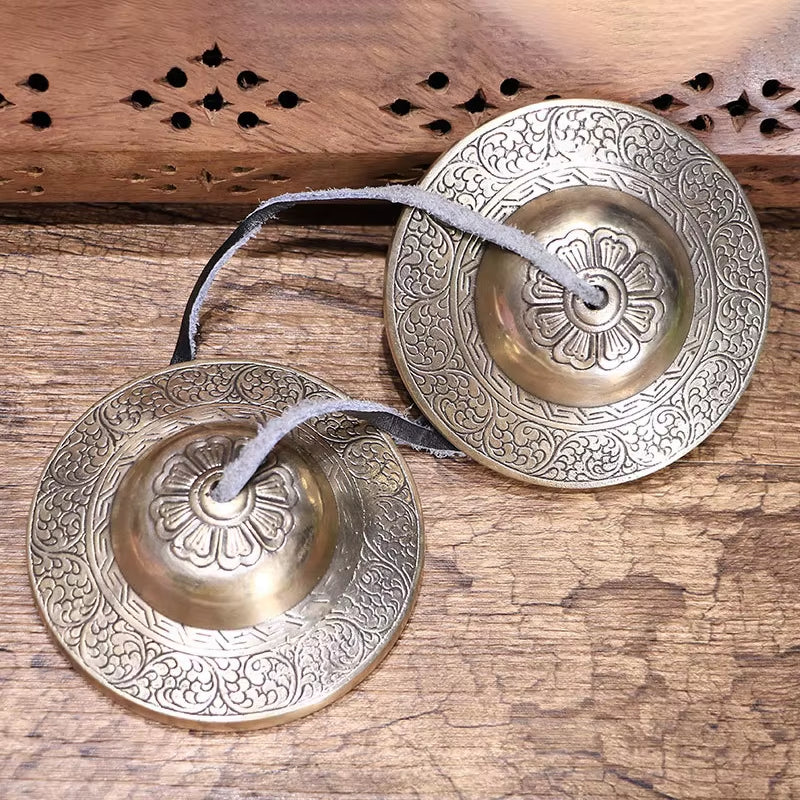 Ornate Tibetan Tingsha Bells with intricate floral engravings for meditation and sound healing