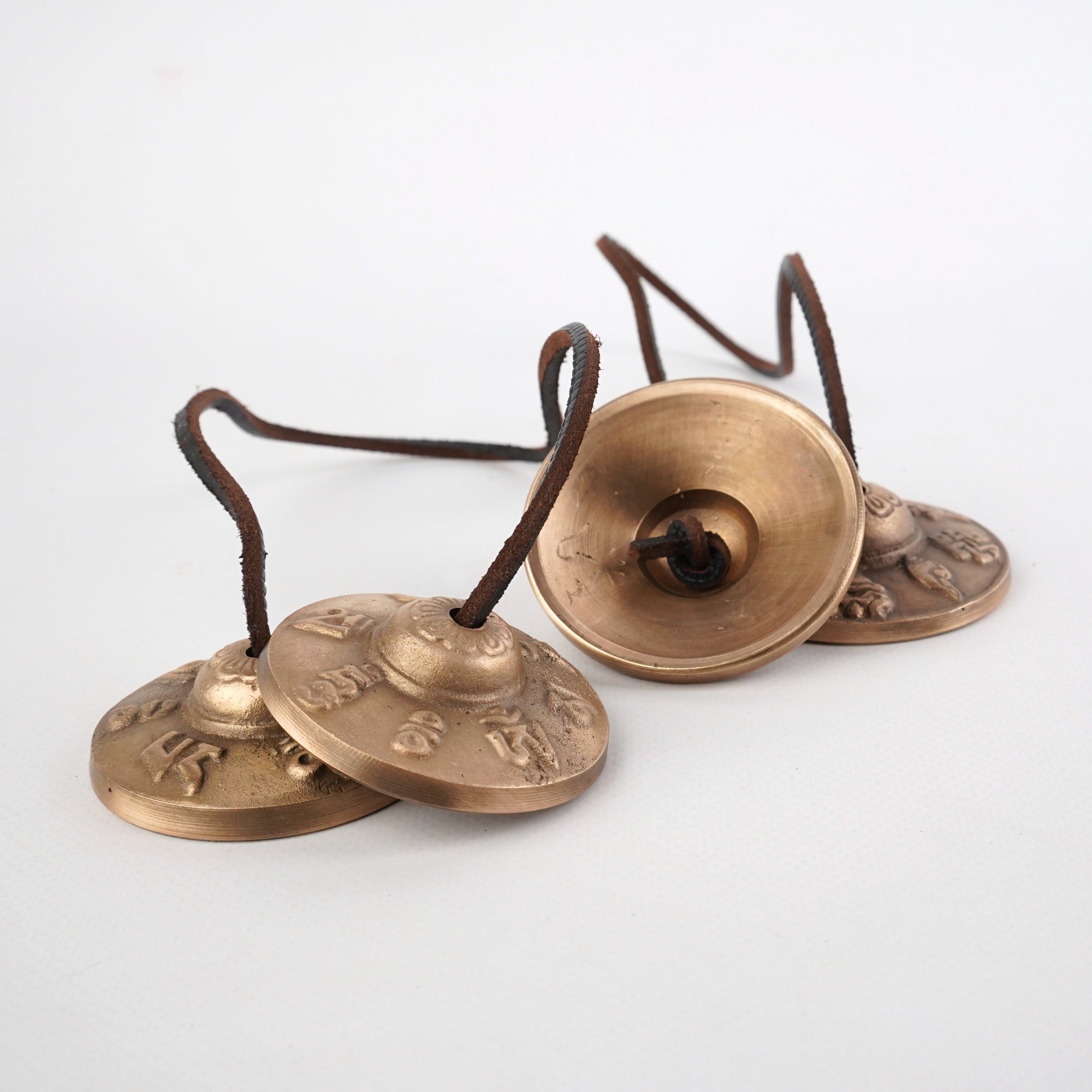 Bronze Tibetan meditation bells with intricate engravings on Tingsha cymbals