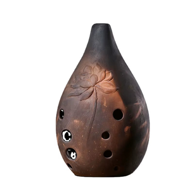 Brown ceramic ocarina with lotus flower design, a Vintage Ceramic Xun musical instrument