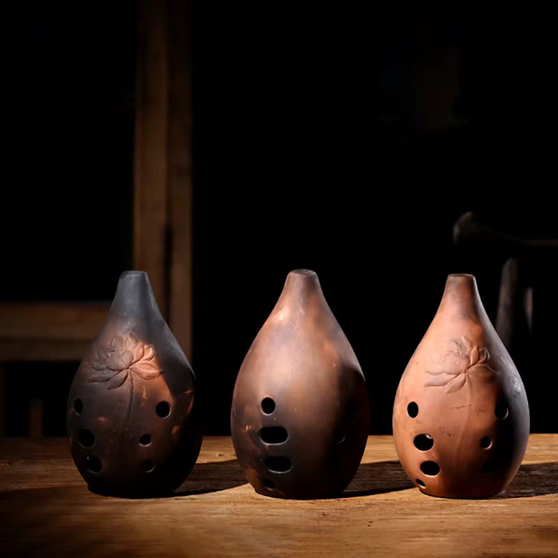 Three teardrop-shaped ceramic ocarina flutes with carved leaf designs. Vintage Ceramic Xun