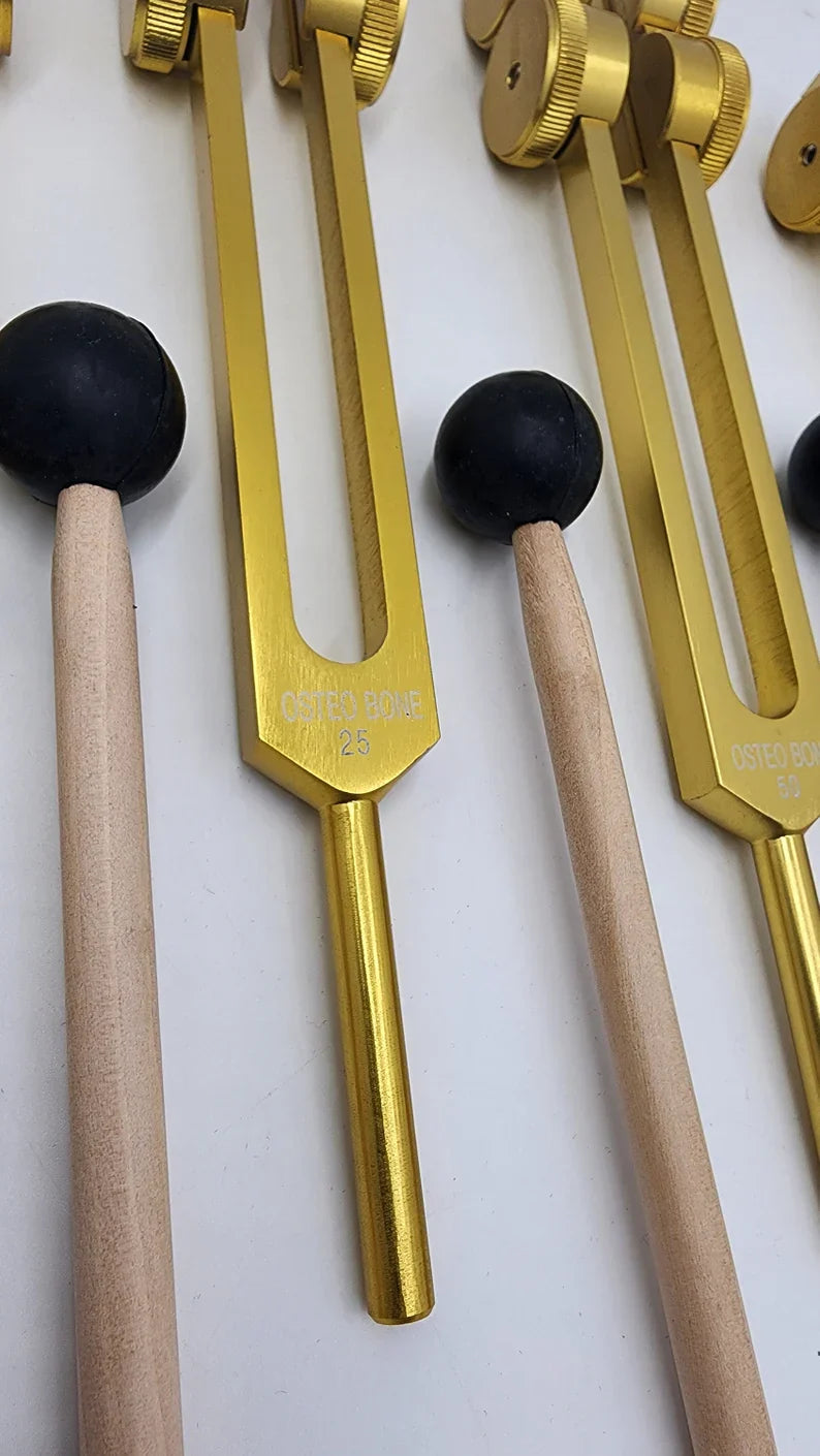 Golden tuning forks with wooden mallets in Weighted Osteo Tuning Fork Set of 4