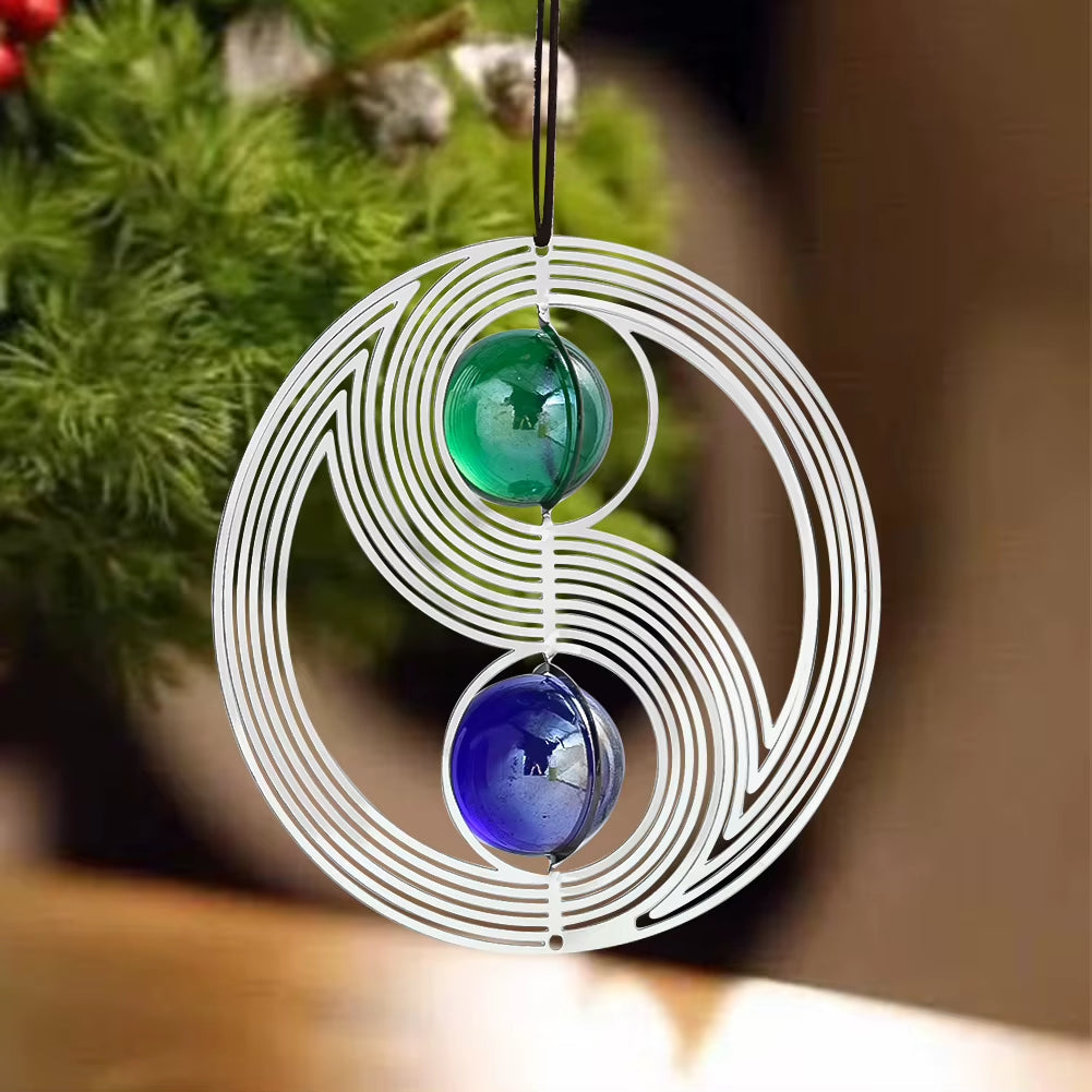 Spiral metal wind spinner with green and blue glass marbles in yin-yang design